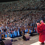 His Holiness the Dalai Lama acknowledging the 11,000 members of the audience wearing white silk scarves at the end of his talk at Veterans Memorial Coliseum in Portland, Oregon on May 11, 2013. Photo/Jeremy Russell/OHHDL