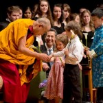 Young children offer flowers to His Holiness the Dalai Lama before the start of the interfaith gathering on 'Spirituality and the Environment' at the University of Portland in Portland, Oregon on May 9, 2013. Photo/Don Farber