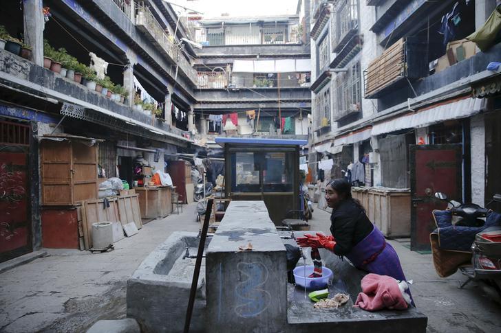 A booth is seen in centre of the courtyard as a Tibetan women washes clothes in Bakhor, in the old part of Lhasa, Tibet Autonomous Region, China on November 16, 2015. In Bakhor, one of the hotbeds of dissent during the riots, the paramilitary presence has been replaced with booths, part of a "grid management" surveillance system aimed at managing society "without gaps, without blind spots, without blanks", according to state media. 